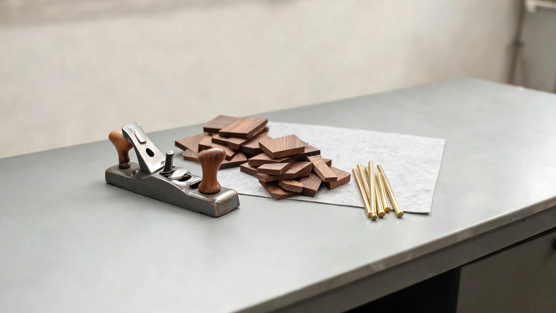 Workshop bench with a hand plane, walnut offcuts and brass rod stock
